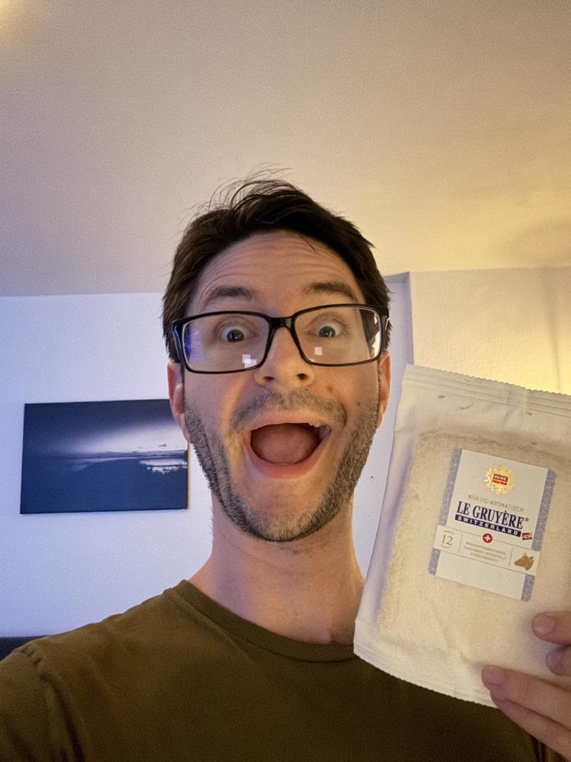 The author holding a pack of Le Gruyère, extremely happy